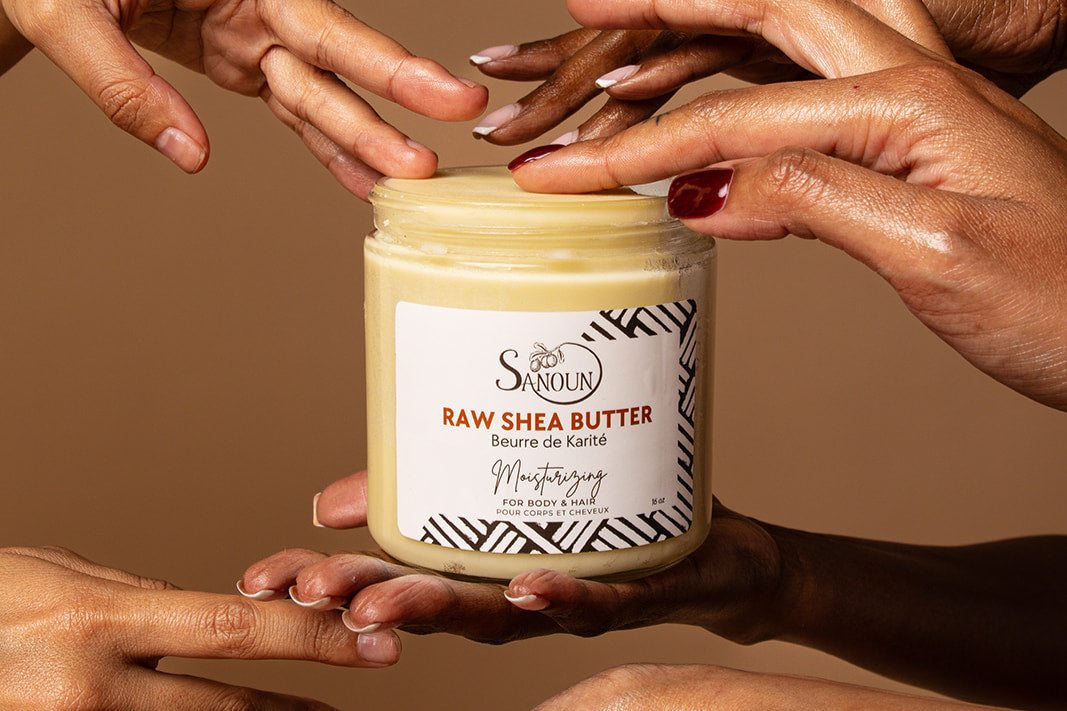 Hands dipping in raw shea butter