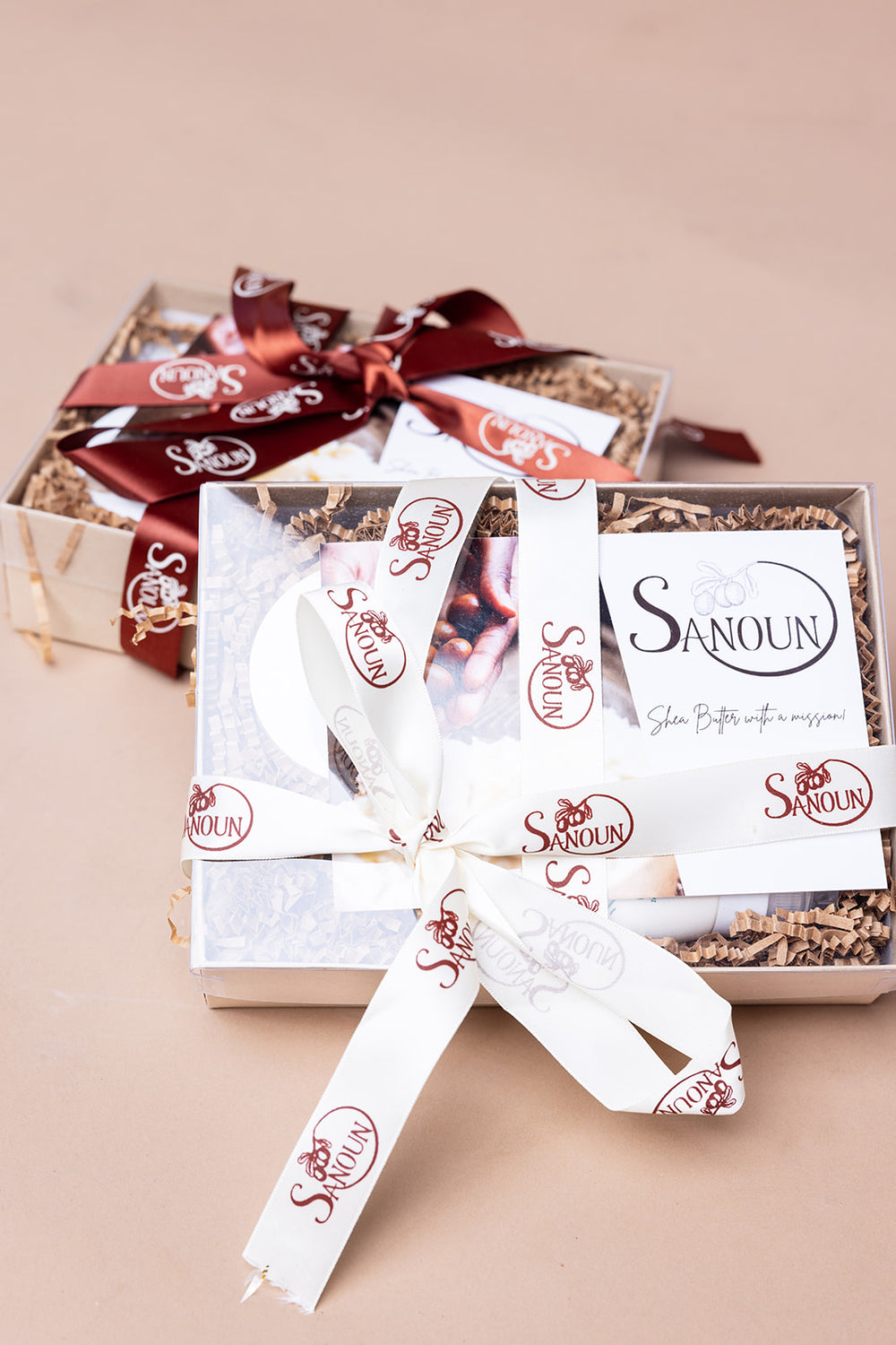 Two Sanoun ritual gift boxes tied with branded ribbons on a warm neutral background